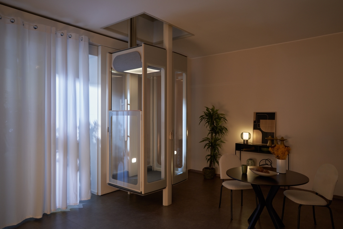 Domácí výtah Stannah Uplifts mezi patry v moderním interiéru při nočním osvětlení.